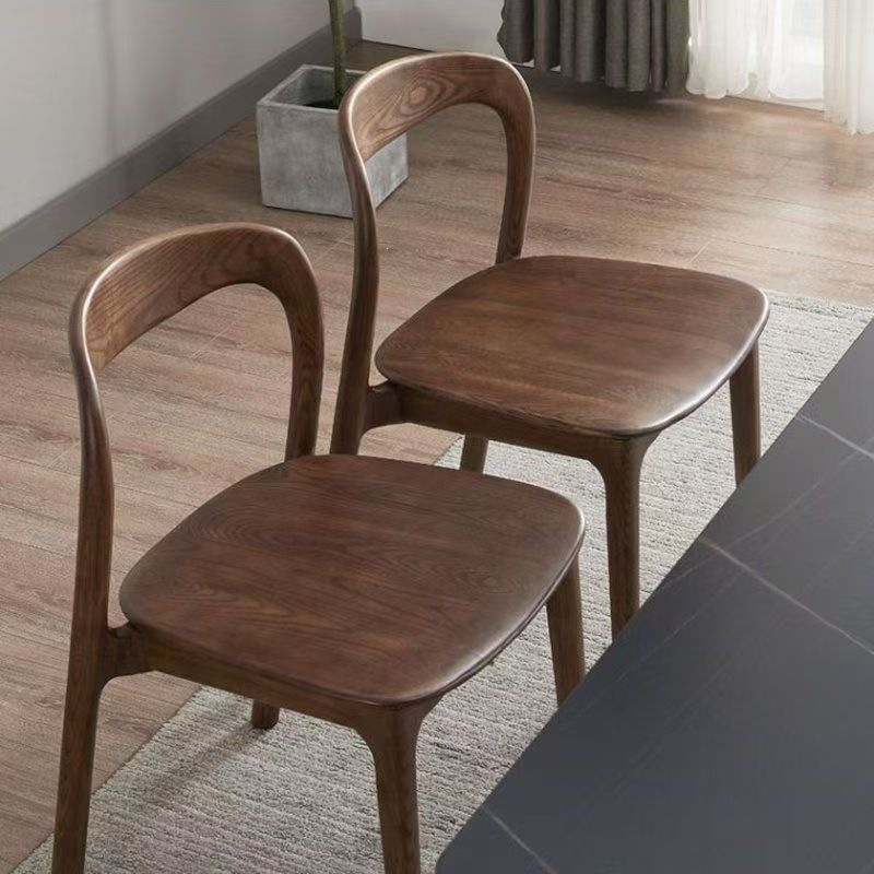 Dos sillas nórdicas de madera maciza junto a una mesa de comedor